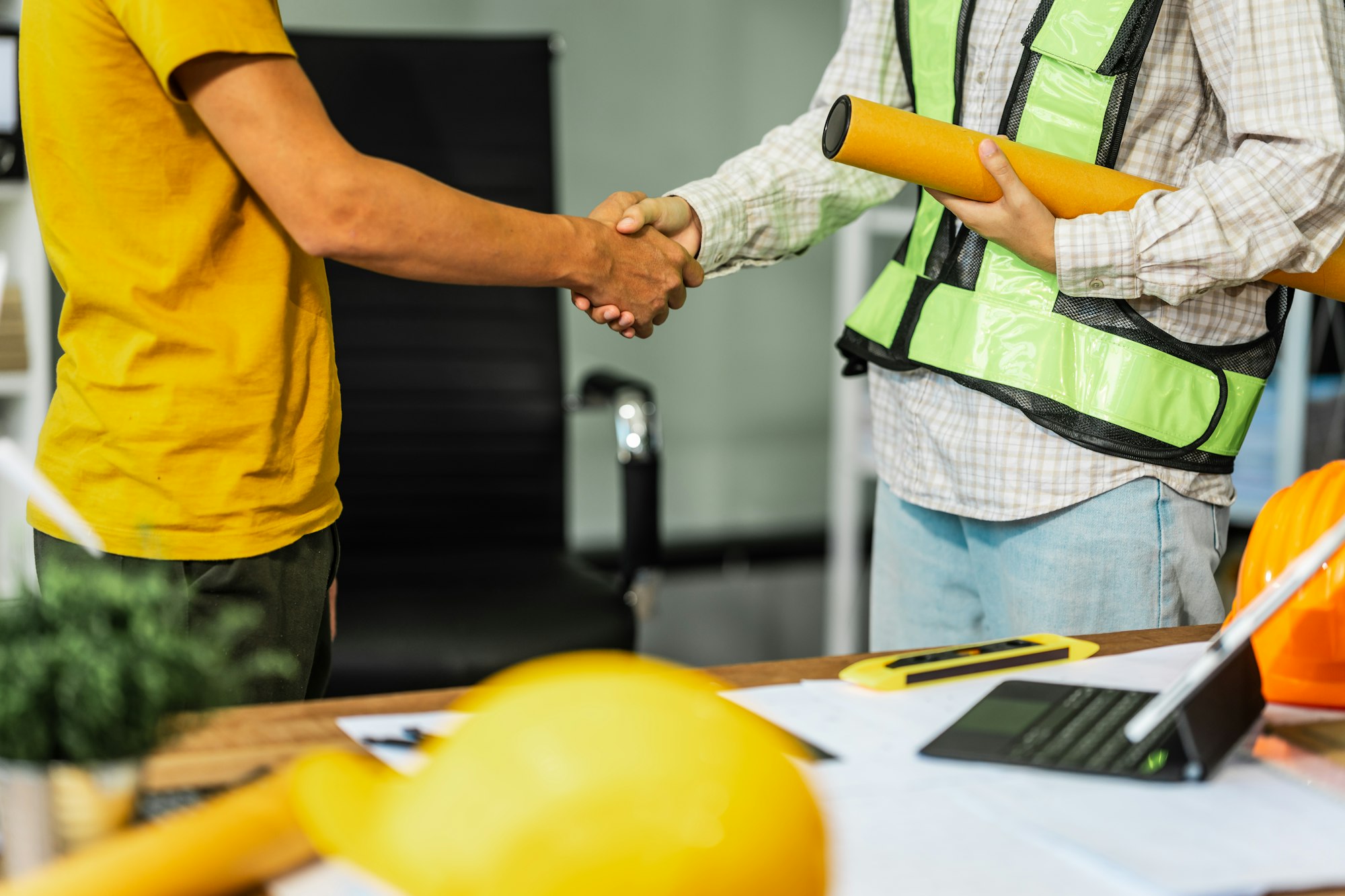 Shaking hands, Female architect engineer is drafting blueprints using CAD software, focusing